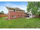 A brick home's backyard features a well-maintained lawn, patio with a table and chairs, and a screen room at 6011 Welch St, Arvada, CO 80004