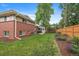 A brick home's backyard features a well-maintained lawn, patio with a table and chairs, and a screen room at 6011 Welch St, Arvada, CO 80004