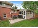 Backyard patio with outdoor dining and grilling area adjacent to enclosed sunroom at 6011 Welch St, Arvada, CO 80004