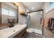 Updated bathroom with a modern vanity, decorative mirror, and a glass-enclosed shower at 6011 Welch St, Arvada, CO 80004