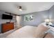 Cozy bedroom featuring a sliding barn door, a large window, and carpet flooring at 6011 Welch St, Arvada, CO 80004