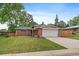 Charming brick home with a well-manicured lawn, mature trees, and attached two-car garage at 6011 Welch St, Arvada, CO 80004