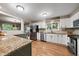 Modern kitchen with granite countertops, white cabinets, and stainless steel appliances at 6011 Welch St, Arvada, CO 80004