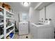 Bright laundry room featuring a modern washer and dryer and ample storage shelves at 6011 Welch St, Arvada, CO 80004