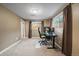 Home office featuring neutral walls, carpet flooring, two windows, and a modern black desk at 6011 Welch St, Arvada, CO 80004