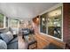Cozy sunroom featuring wicker furniture, brick accent wall, and glass sliding doors at 6011 Welch St, Arvada, CO 80004
