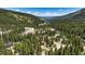 Aerial view of a charming log cabin surrounded by a lush forest and winding mountain roads at 29 Gregory Cir, Breckenridge, CO 80424