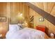 Comfortable bedroom featuring wood-paneled walls, a cozy bed and sloped ceilings at 29 Gregory Cir, Breckenridge, CO 80424