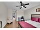 Bedroom with a ceiling fan, a bed with a pink coverlet, chair, and hardwood floors at 2616 E Cherry Creek South Dr, Denver, CO 80209
