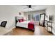 Cozy bedroom features a modern bed frame, ceiling fan, window with shutters, and wood flooring at 2616 E Cherry Creek South Dr, Denver, CO 80209