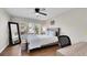 Cozy bedroom features a modern bed frame, ceiling fan, window with shutters, and wood flooring at 2616 E Cherry Creek South Dr, Denver, CO 80209