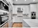 Bright kitchen features white cabinetry, stainless appliances and fixtures at 2616 E Cherry Creek South Dr, Denver, CO 80209