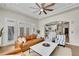 Bright living room features a ceiling fan, tan leather sofa, stylish seating, and access to an open kitchen at 2616 E Cherry Creek South Dr, Denver, CO 80209