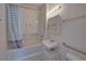 Compact bathroom features a tub-shower, a vanity sink, and grab bars for added convenience and safety at 5723 Zephyr St, Arvada, CO 80002