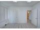 Bright bedroom showcases multiple doorways, crisp white walls, and new vinyl flooring for modern appeal at 5723 Zephyr St, Arvada, CO 80002