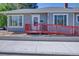 Exterior view of a home featuring an accessible red ramp and manicured landscaping at 5723 Zephyr St, Arvada, CO 80002