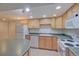 Bright kitchen features wood cabinets, white appliances, and ample countertop space for meal preparation at 5723 Zephyr St, Arvada, CO 80002
