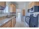 Bright kitchen featuring wood cabinets, granite countertops, and stainless steel appliances at 5723 Zephyr St, Arvada, CO 80002