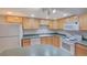 Spacious kitchen featuring neutral cabinets, green counters, and white appliances at 5723 Zephyr St, Arvada, CO 80002