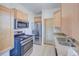 Modern kitchen with stainless steel appliances, light wood cabinets, and granite countertops at 5723 Zephyr St, Arvada, CO 80002