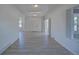 Spacious living room featuring neutral walls, modern lighting, and multiple doorways for a connected living space at 5723 Zephyr St, Arvada, CO 80002