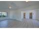 Spacious living room with neutral walls, large windows, and an open layout to other rooms in the home at 5723 Zephyr St, Arvada, CO 80002