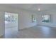 Spacious living room with neutral walls, large windows, and an open layout to other rooms in the home at 5723 Zephyr St, Arvada, CO 80002