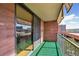 Brick balcony featuring green outdoor carpet, a metal railing, and views of the surrounding buildings at 1301 Speer Blvd # 403, Denver, CO 80204