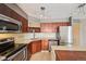Contemporary kitchen featuring stainless steel appliances, dark wood cabinetry, and ample counter space, stylish lighting at 1301 Speer Blvd # 403, Denver, CO 80204