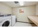 Well-lit laundry room featuring modern washer and dryer units and a folding table at 1301 Speer Blvd # 403, Denver, CO 80204