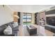 Bright living room with a comfortable gray sofa and a sliding glass door leading to a balcony with mountain views at 1301 Speer Blvd # 403, Denver, CO 80204
