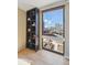 Living room nook with custom built-in shelving, a large window framing the city skyline, and bright sunlight at 1301 Speer Blvd # 403, Denver, CO 80204