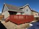 Image of a red wood deck in the backyard of a brick and gray two story home at 6610 Monaco Way, Brighton, CO 80602