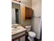 Standard bathroom featuring a wood cabinet, a toilet, sink, and towel bar at 6610 Monaco Way, Brighton, CO 80602