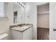 Bathroom with granite countertop, white vanity, and opens to bedroom at 6610 Monaco Way, Brighton, CO 80602