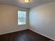 Bright bedroom featuring a window and hardwood-style flooring at 6610 Monaco Way, Brighton, CO 80602