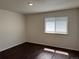 Cozy bedroom featuring hardwood floors, neutral paint, and natural light from a window at 6610 Monaco Way, Brighton, CO 80602