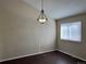 Dining area featuring a modern chandelier, window with blinds and wood-look floors at 6610 Monaco Way, Brighton, CO 80602