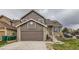 Charming two-story brick and siding home featuring an attached garage and landscaped front yard at 6610 Monaco Way, Brighton, CO 80602