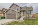 Charming two-story brick and siding home featuring an attached garage and landscaped front yard at 6610 Monaco Way, Brighton, CO 80602