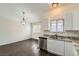 Bright kitchen with stainless steel dishwasher, granite countertops, and wood floors at 6610 Monaco Way, Brighton, CO 80602