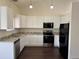 Modern kitchen with white cabinets, granite countertops, and stainless steel appliances at 6610 Monaco Way, Brighton, CO 80602