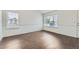 Bright living room with wood floors and two windows providing natural light at 6610 Monaco Way, Brighton, CO 80602