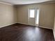 Living room features a door to outside, neutral walls and wood-look floors at 6610 Monaco Way, Brighton, CO 80602