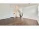 Open-concept living space featuring wood floors, white walls, and a staircase at 6610 Monaco Way, Brighton, CO 80602