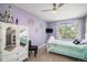 Bright bedroom featuring lavender walls, a white bed, and a ceiling fan at 6039 S Ukraine Cir, Aurora, CO 80015