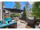 Spacious outdoor deck area with ample seating, large sun umbrella, a gas grill, and a fire pit at 6039 S Ukraine Cir, Aurora, CO 80015