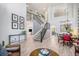 Open floor plan showcasing a staircase, dining room, and living area with modern decor and abundant natural light at 6039 S Ukraine Cir, Aurora, CO 80015