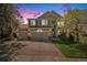 Stunning exterior view of a well-maintained home with a three-car garage, lush landscaping, and a welcoming entrance at 6039 S Ukraine Cir, Aurora, CO 80015