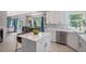 Bright kitchen featuring white cabinetry, stainless steel appliances, a center island, and a view to the dining area at 6039 S Ukraine Cir, Aurora, CO 80015